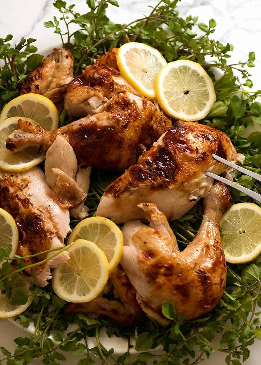 Platter of carved roast chicken on a plate, ready to be served