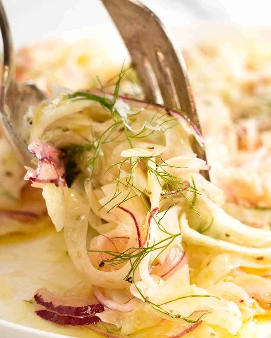 Close up of forks picking up Fennel Salad