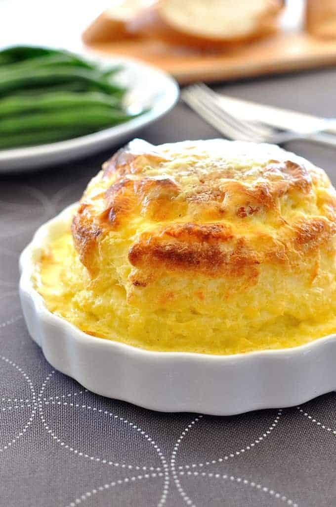 Souffle you can make ahead - freezer and refrigerator friendly. Cheesy, light as air soufflé covered in a luscious creamy sauce. And easy!