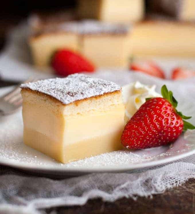 Magic Three Layer Custard Cake with strawberry on a white plate