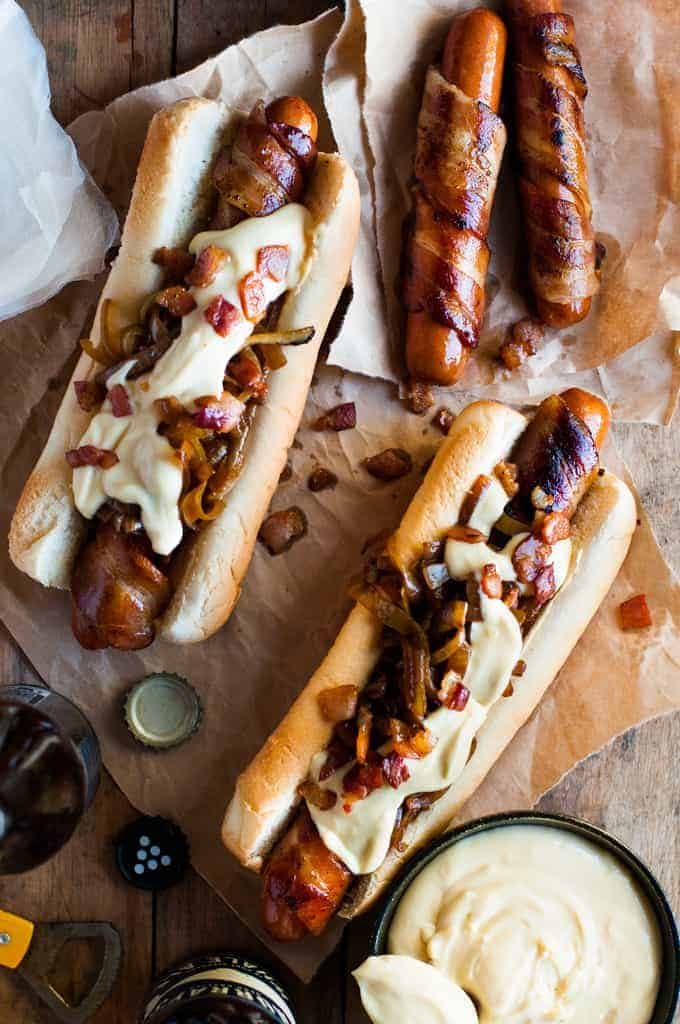 Bacon Wrapped Hot Dogs with Cheese Sauce with a pot of cheese sauce
