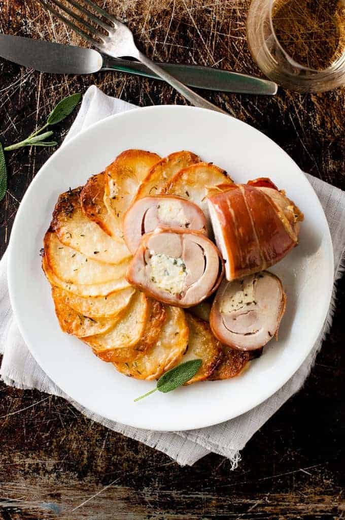 Prosciutto Wrapped Chicken and Scalloped Potatoes on a white plate, ready to be eaten