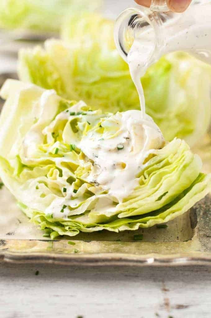 Pouring Ranch Dressing on Lettuce Wedges for Lettuce Wedge Salad