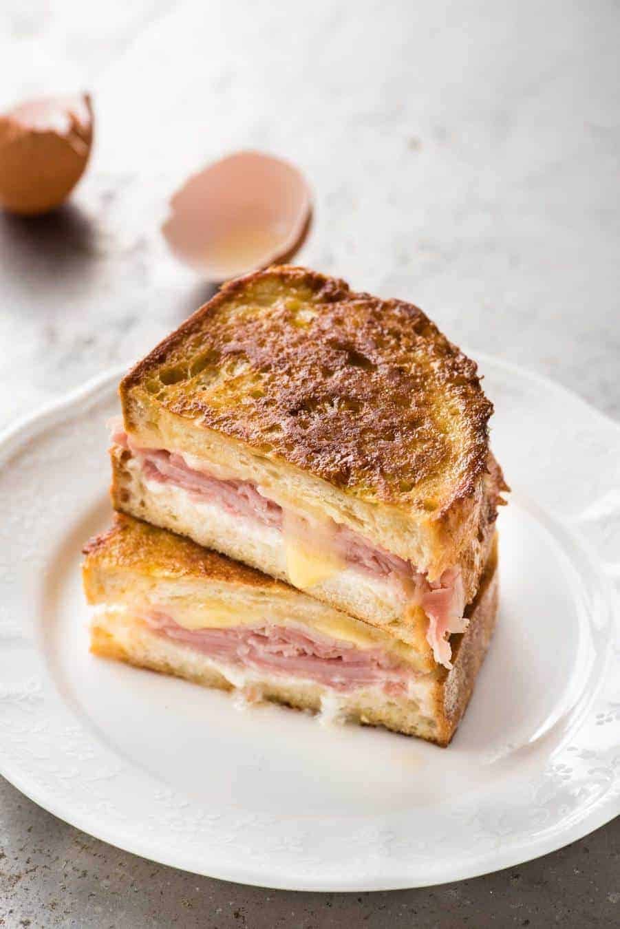 Monte Cristo Sandwich cut in half and stacked on each other on a small white plate, ready to be eaten.