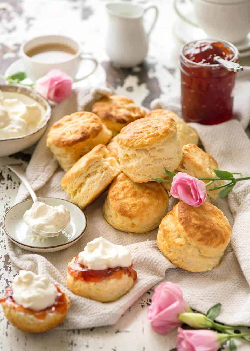 An afternoon tea with scones, jam and cream, with coffee and tea.