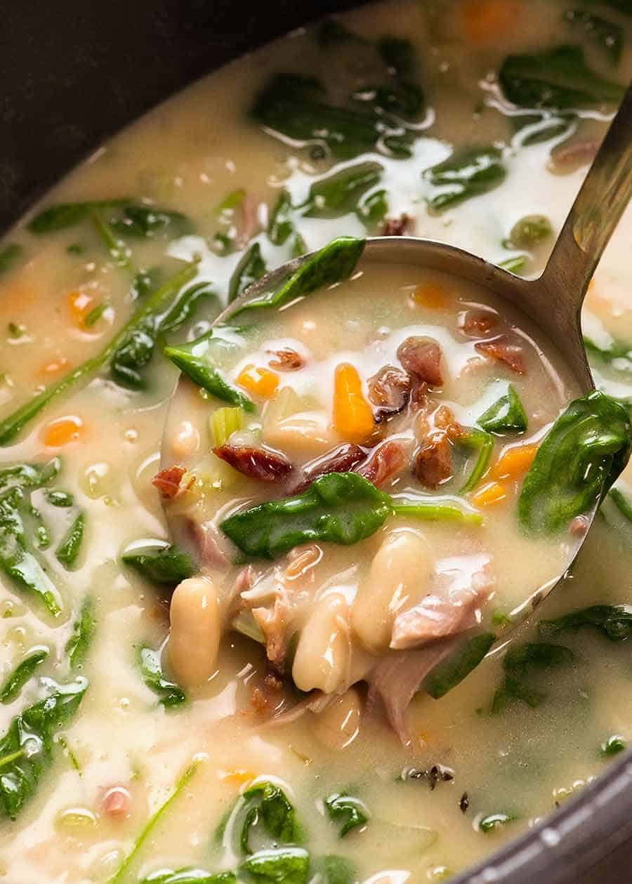 Close up of ladle scooping up Slow Cooker Ham Bone Soup with Beans 