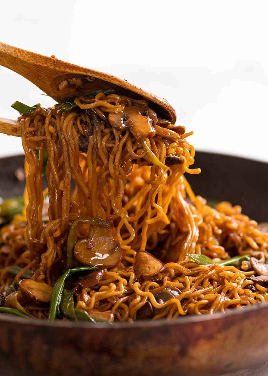 Asian Mushroom Ramen Noodles being tossed with wooden spoons