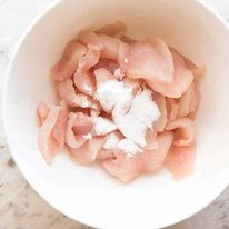 Bowl of raw chicken with baking soda to be tenderised