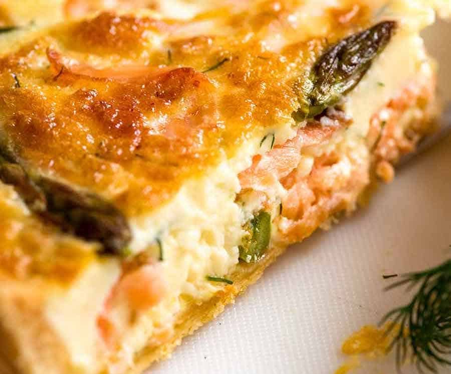 Slice of Salmon Quiche showing the custardy inside with flakes of salmon