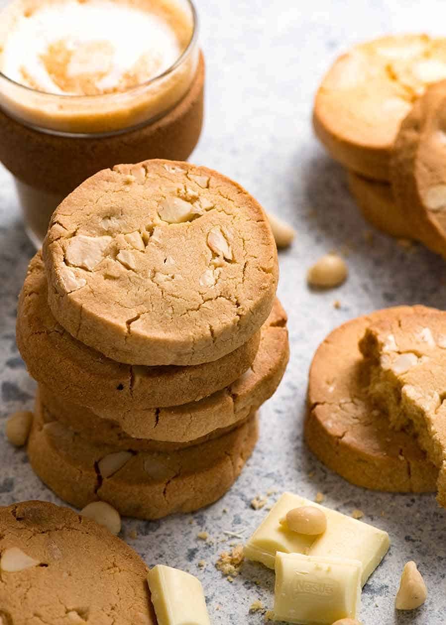 Stacks of White Chocolate Macadamia Nut Cookies with a cup of latte