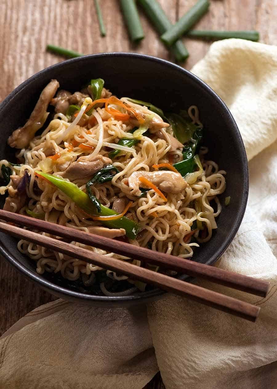 Chow Mein Ramen Noodles in a rustic black bowl with chopsticks, ready to be eaten