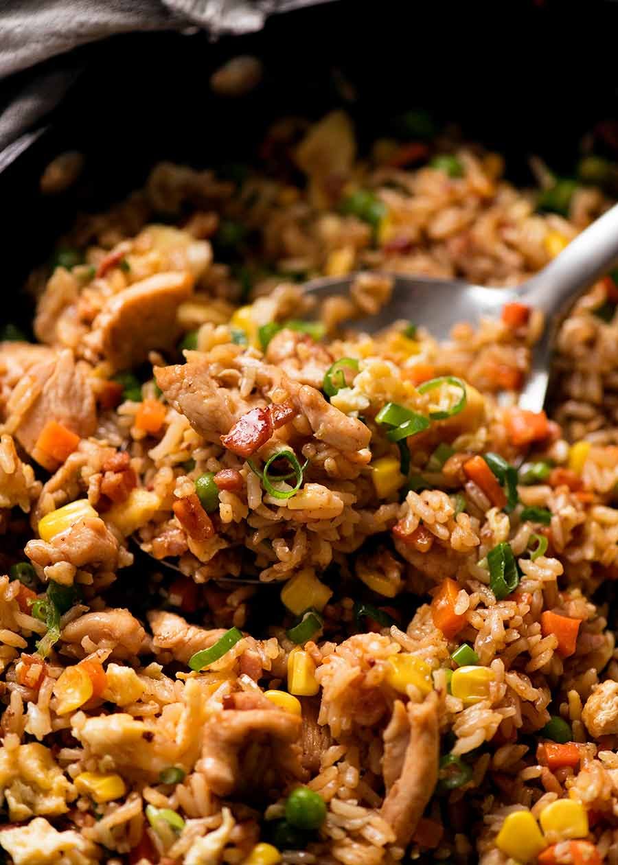 Close up of Chicken Fried Rice with seasoned chicken, bacon, peas, carrots, corn and fluffy egg, ready to be served.