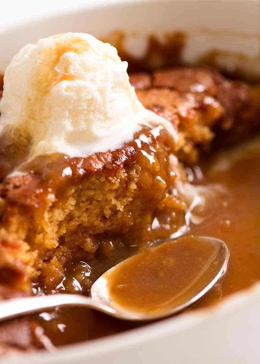 Close up of Self Saucing Butterscotch Pudding in a baking dish, being served
