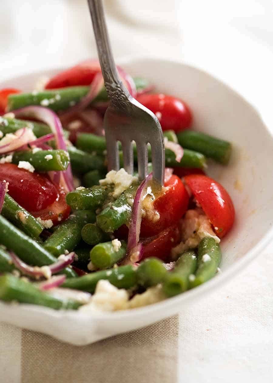 Close up of forkful of Green Bean Salad with Cherry Tomatoes and Feta