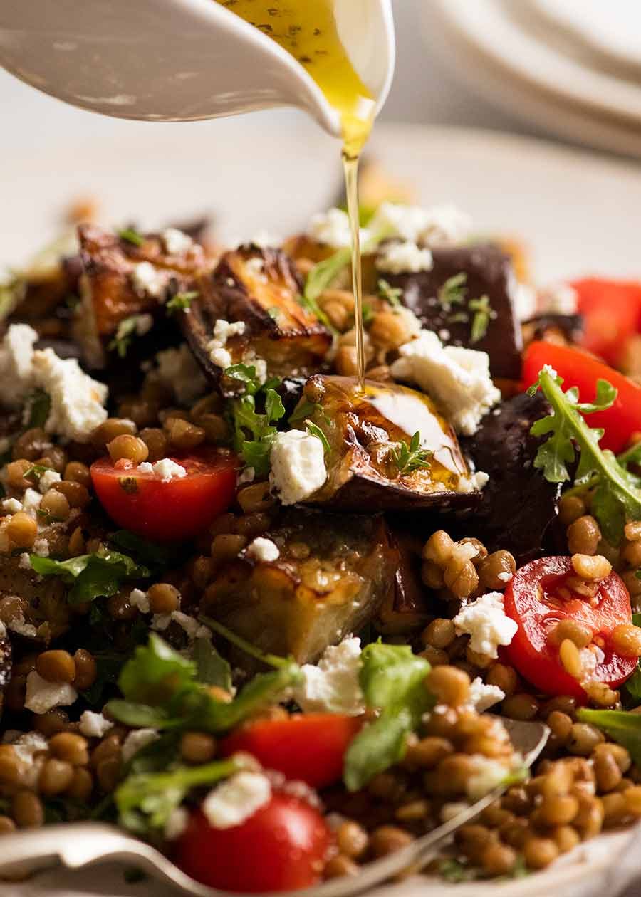 Drizzling lemon dressing over Roasted Eggplant Lentil Salad