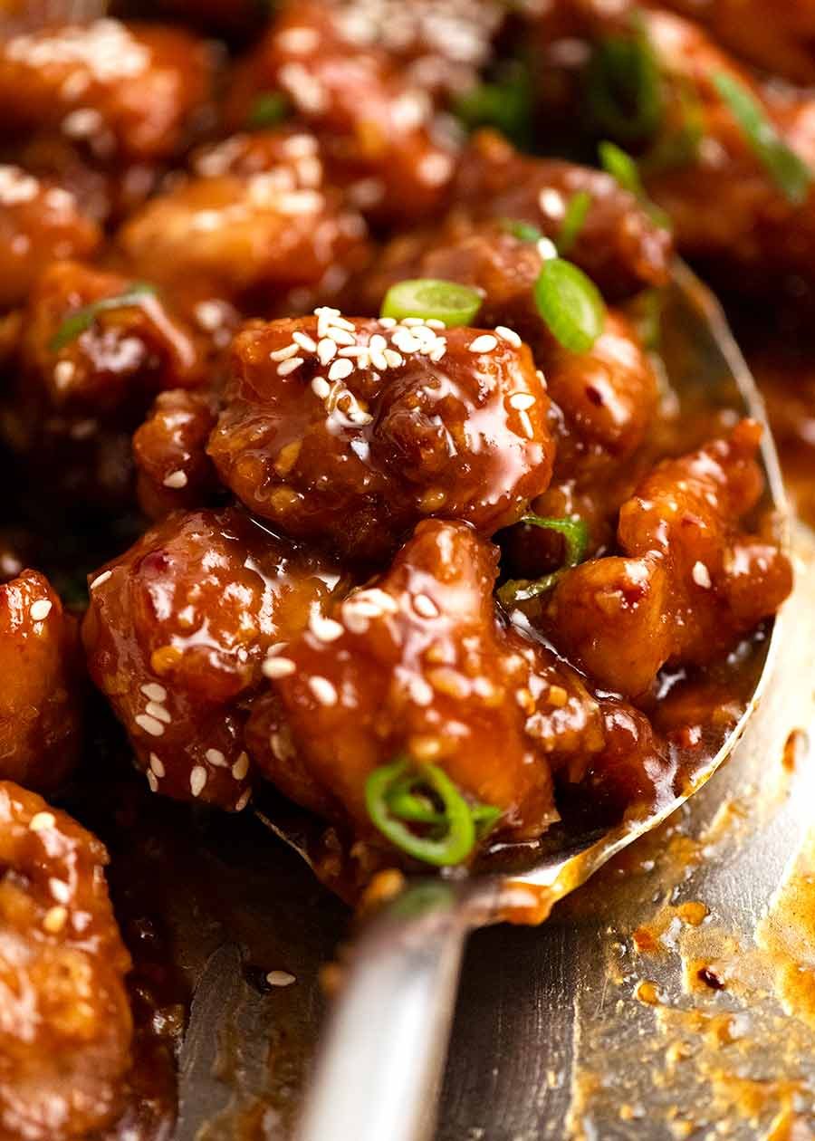 Spoon scooping up General Tso's Chicken from a skillet