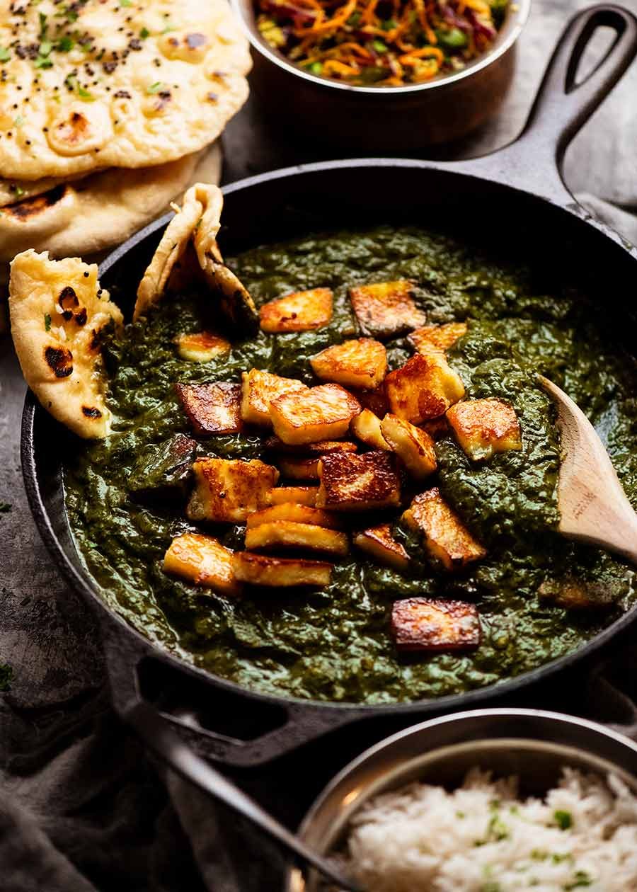 Palak Paneer - Indian Spinach Curry with Cheese in a black skillet, fresh off the stove