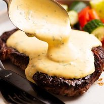 Spooning Bearnaise Sauce over steak