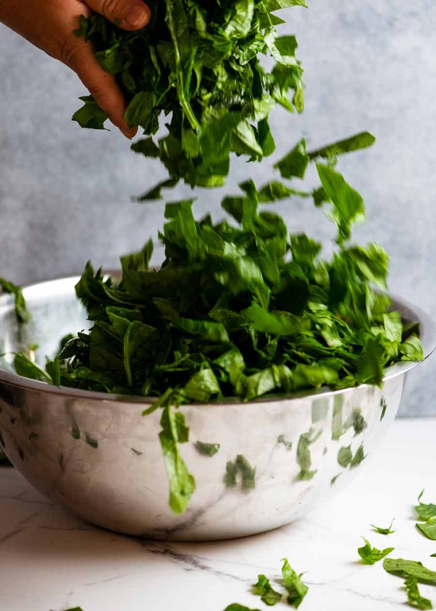 Tumbling chopped fresh spinach into a big bowl