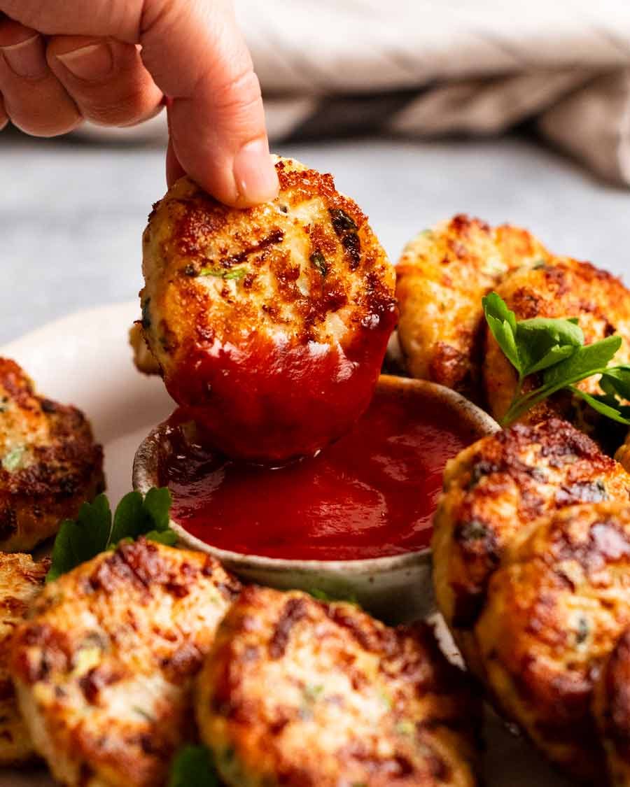 Dipping a chicken rissole in ketchup